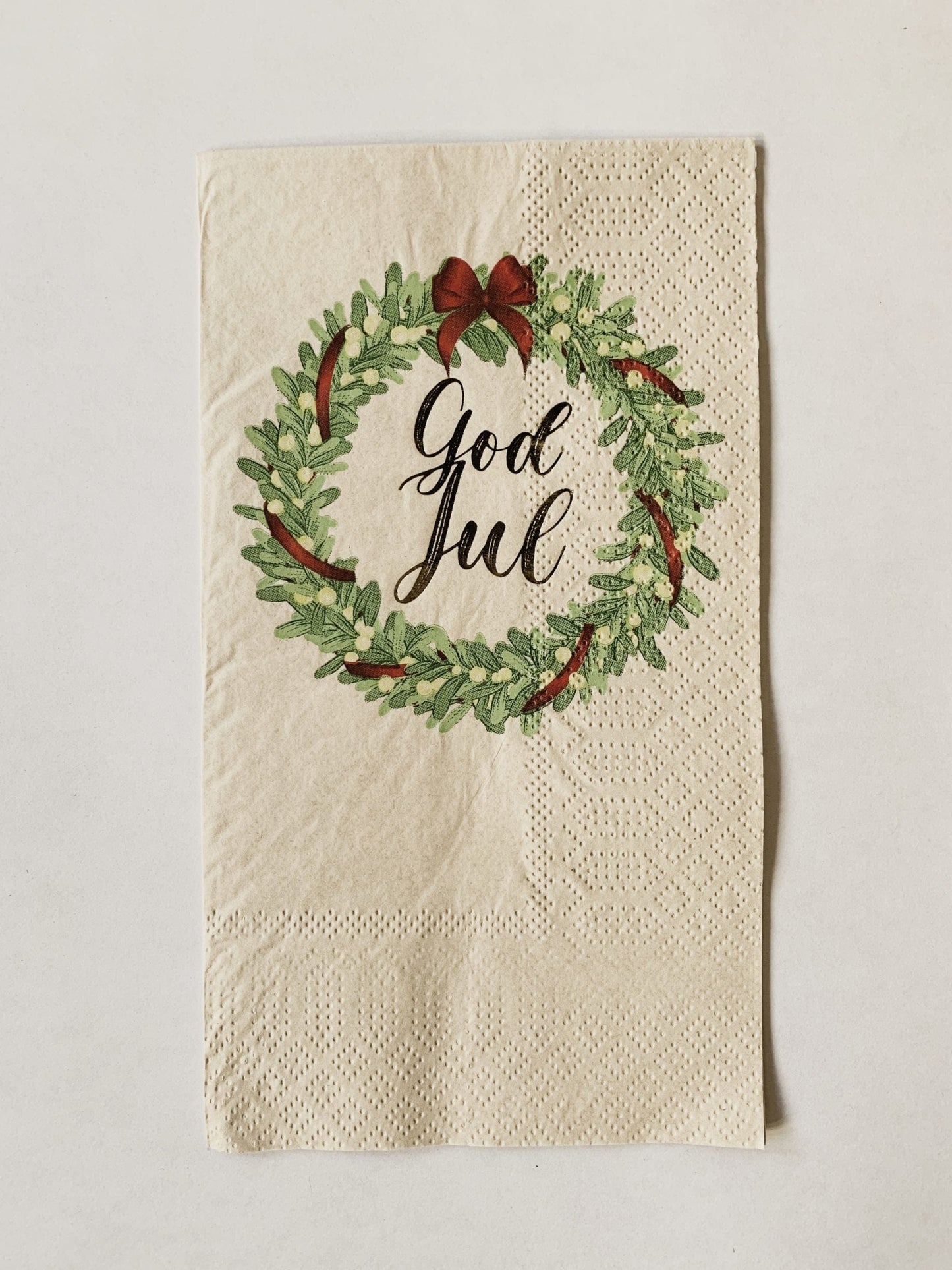 Dekk bordet og inviter familie og venner i denne magiske tiden på året! Serviett fra Trend Design med en krans rundt teksten "God Jul". Ferdig brettet i en perfekt størrelse, av bambus.