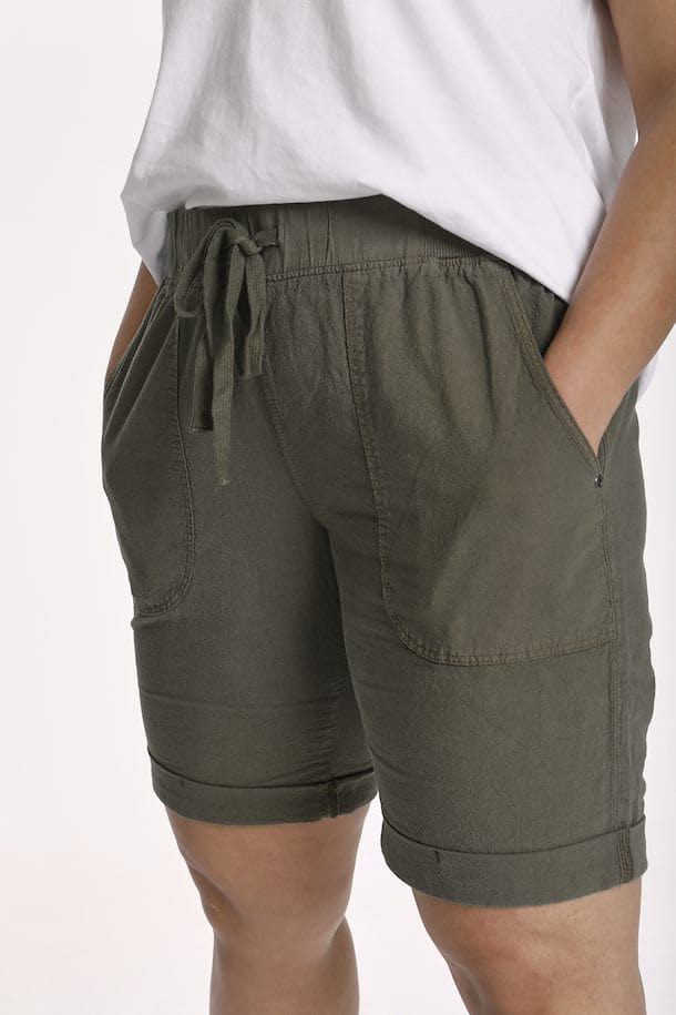 Myk armygrønn shorts med god stretch og strikk i livet med lommer. Snøre i livet gjør shortsen justerbar. Bena har en liten oppbrett som en fin detalj, fra Kaffe Curve.