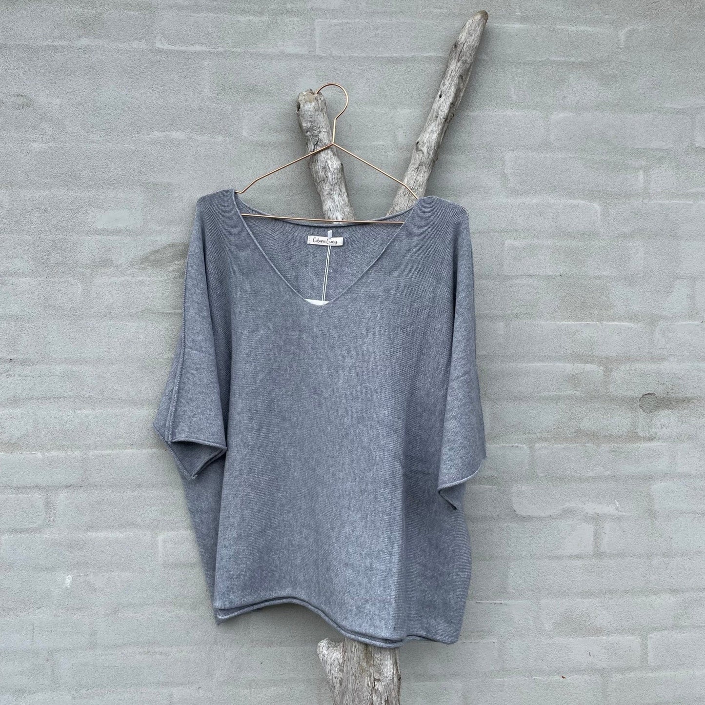 En riktig myk og herlig finstrikket grå genser med v-hals og korte ermer. Denne er noe kortere og derfor perfekt over skjorter og t-shirts. Super å ha i base garderoben.
