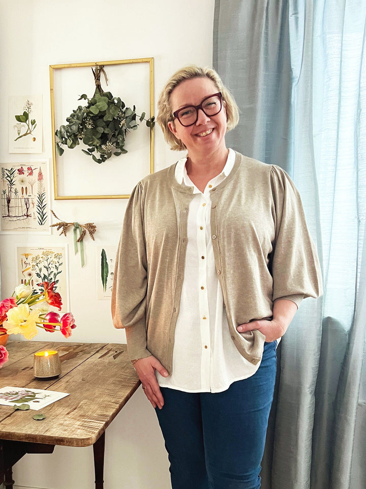 En nydelig off-white bluse med en klassisk krage og gullfargede knapper fra Zoey. Korte ermer med en romantisk strikk. Dette er en løs og ledig bluse som er riktig fin til jeans.