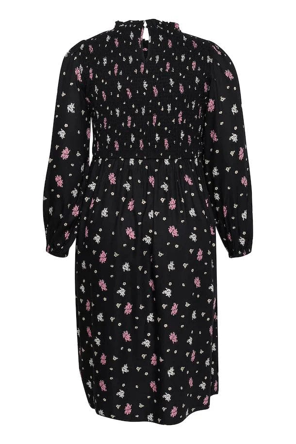 En halvlang sort kjole med rosa blomstemønster. Kjolen har en myk strikk i front som gir en riktig fin innsvingt passform! En flott kjole fra Kaffe Curve til både jobb og og festen.