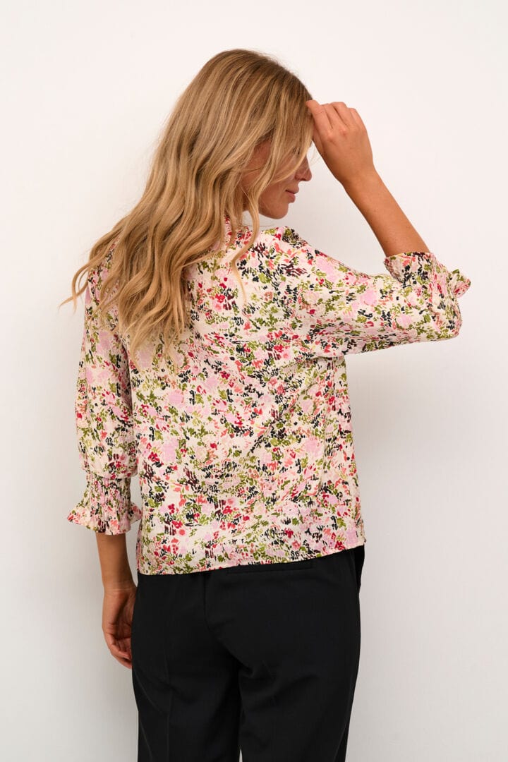 En nydelig bluse med blomster print fra Kaffe på off-white bunn som passer like godt på jobb som til festen.Blusen har v-hals, 3/4 lange ermer med strikk og blonder, en fin detalj.