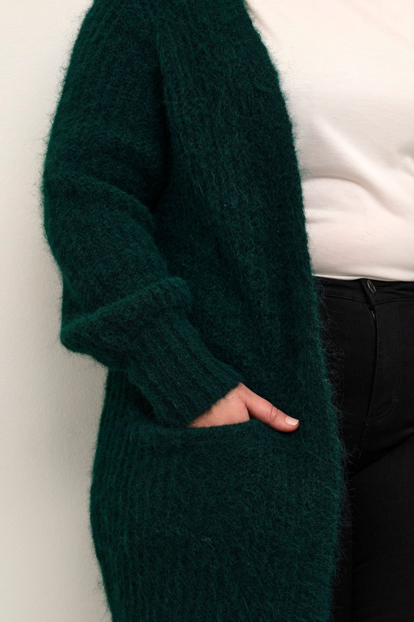 En chunky strikket cardigan i en lekker blågrønn fargen med lommer. Den kommer være god i høst og vinter over dine bluser, skjorter og gensere. God til base garderoben fra Kaffe Curve